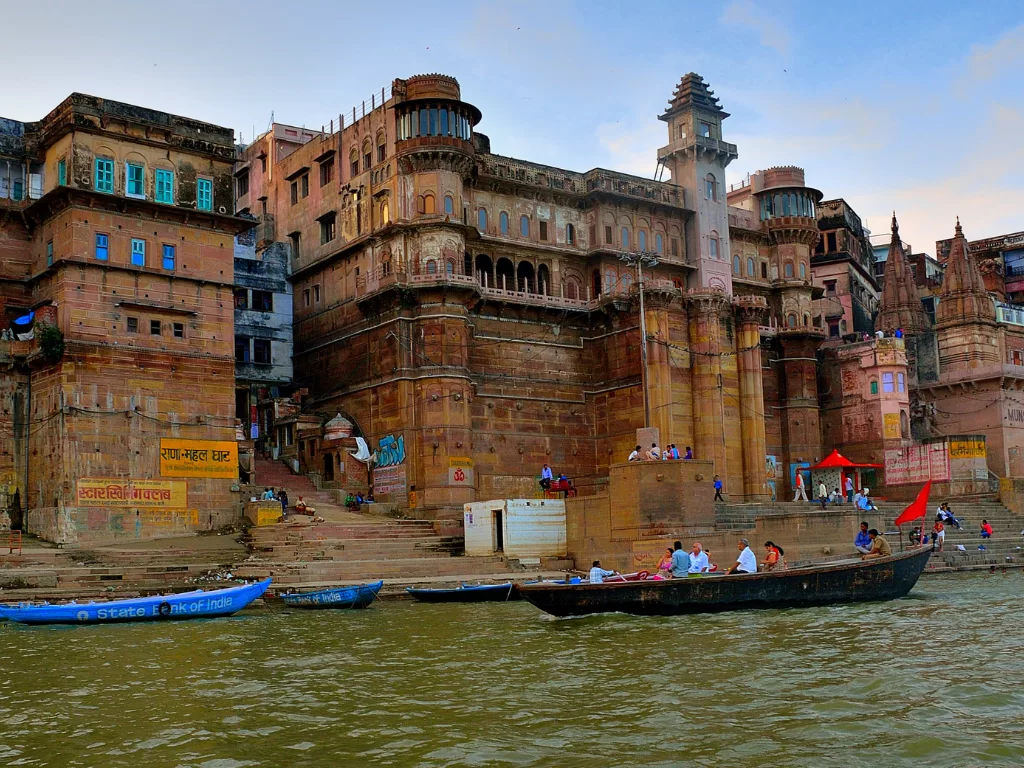 Rana Mahal Ghat palace at Varanasi during evening, featuring towers boats river crowds, perfect cultural Uttar Pradesh tour package.