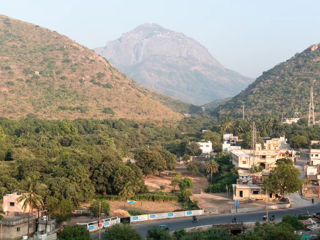 Girnar Jain temples panoramic aerial view from Girnar hill overlooking Junagadh city nestled between sacred peaks, pilgrimage heritage perfect for Gujarat tour packages.