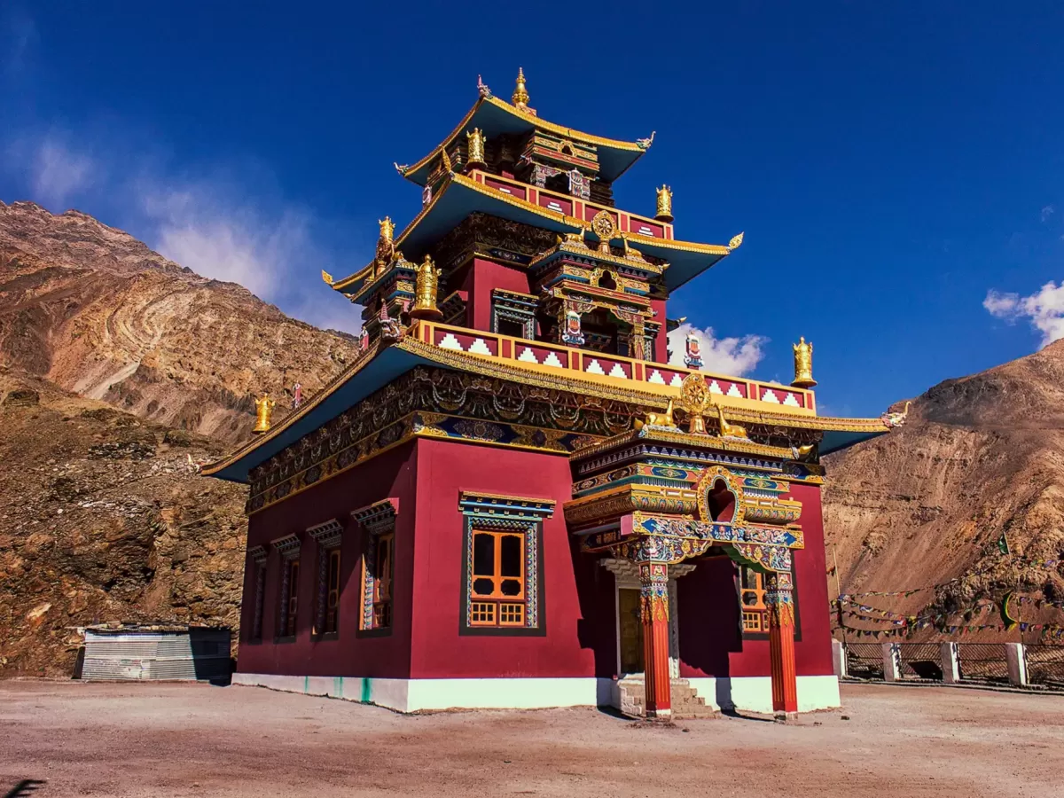 Gue Monastery near Kaza Spiti during clear skies, featuring multi-tiered red gold temple brown rocky mountains, perfect cultural experience Himachal tour package.