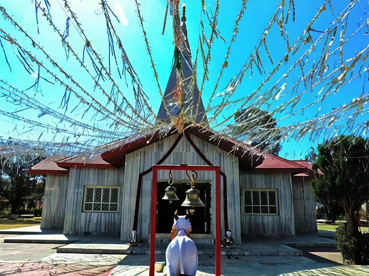 Haidakhan Babaji Temple in Ranikhet, Uttarakhand with prayer flags and bells adorning the wooden shrine, a peaceful spiritual retreat featured in Uttarakhand tour packages
