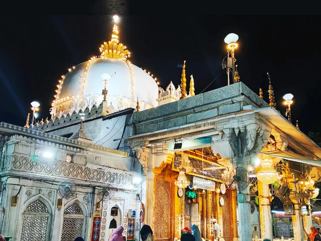 Haji Ali Dargah Mumbai night view featuring illuminated white dome and golden minarets, perfect Mumbai spiritual heritage tour package.