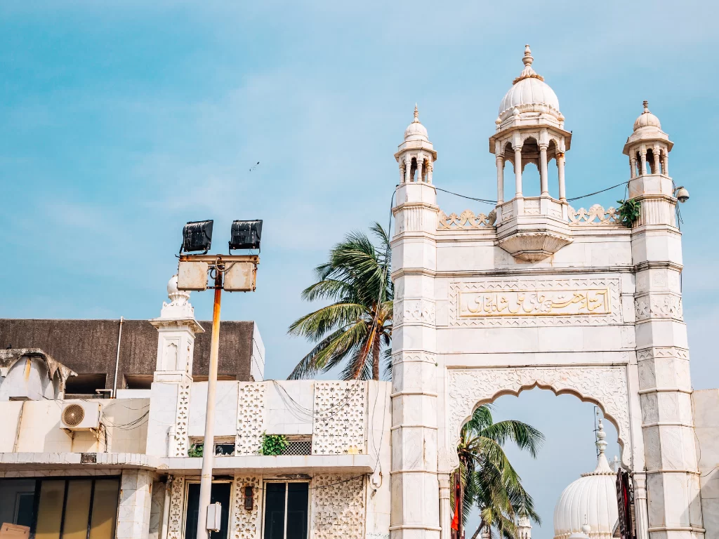 Haji Ali Dargah Mumbai iconic main entrance gate with Indo-Islamic architecture and palm trees, perfect Mumbai spiritual heritage tour package. 