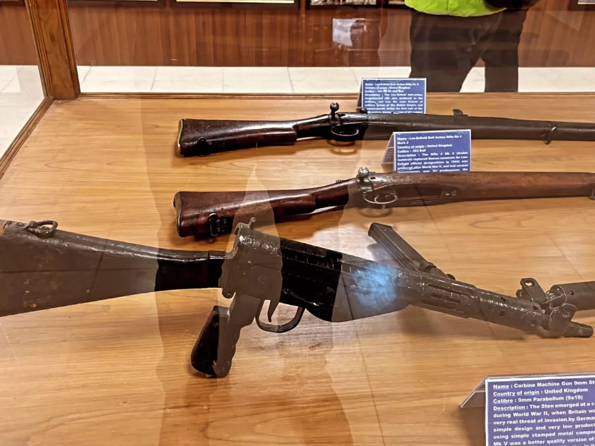 Hall of Fame Leh Ladakh weapons exhibit glass case vintage rifles Lee Enfield Sten gun Bren light machine gun World War era Pakistani captured arms informational plaques military history display.