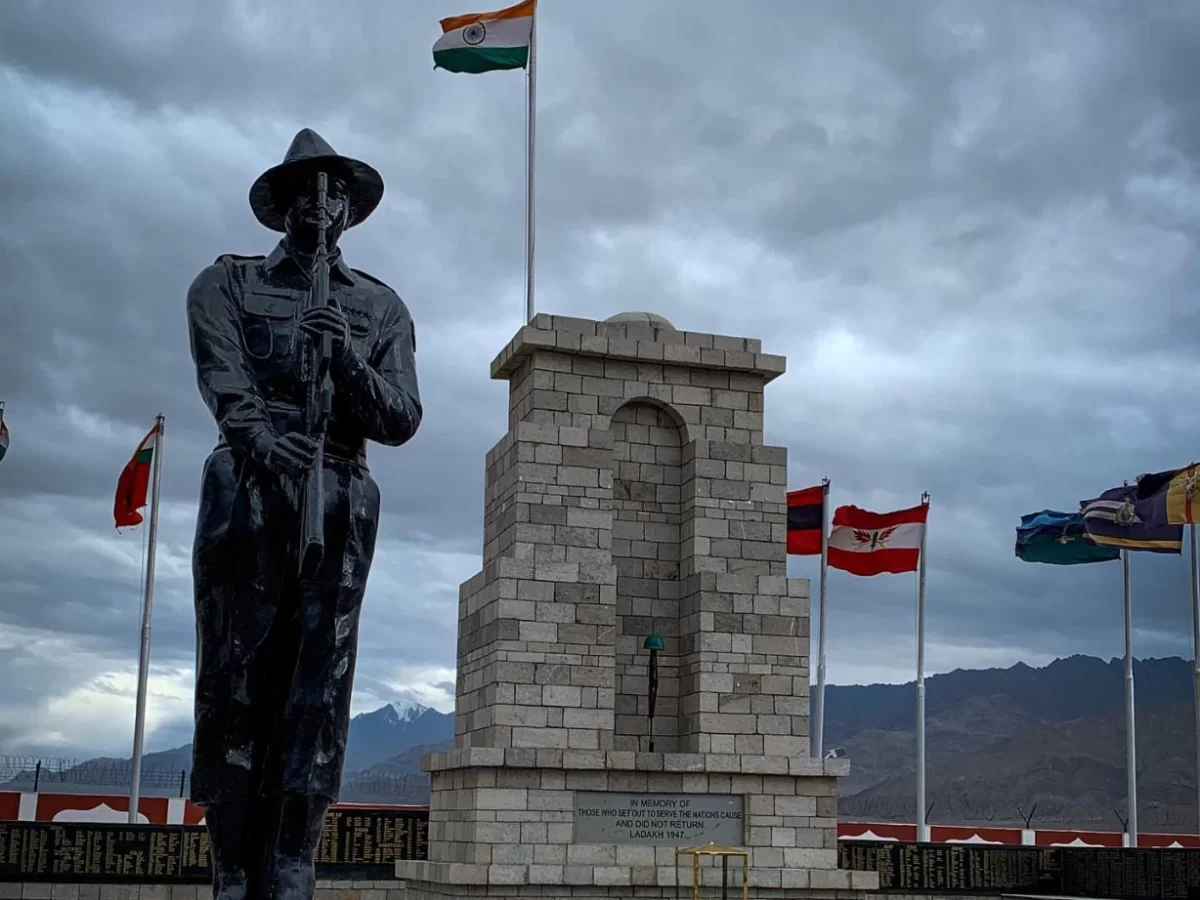Hall of Fame Leh Ladakh Memorial Hall soldier statue rifle hat uniform stone pedestal Indian flag Nepal UK flags cloudy sky mountains war memorial heroes monument Ladakh Scouts.