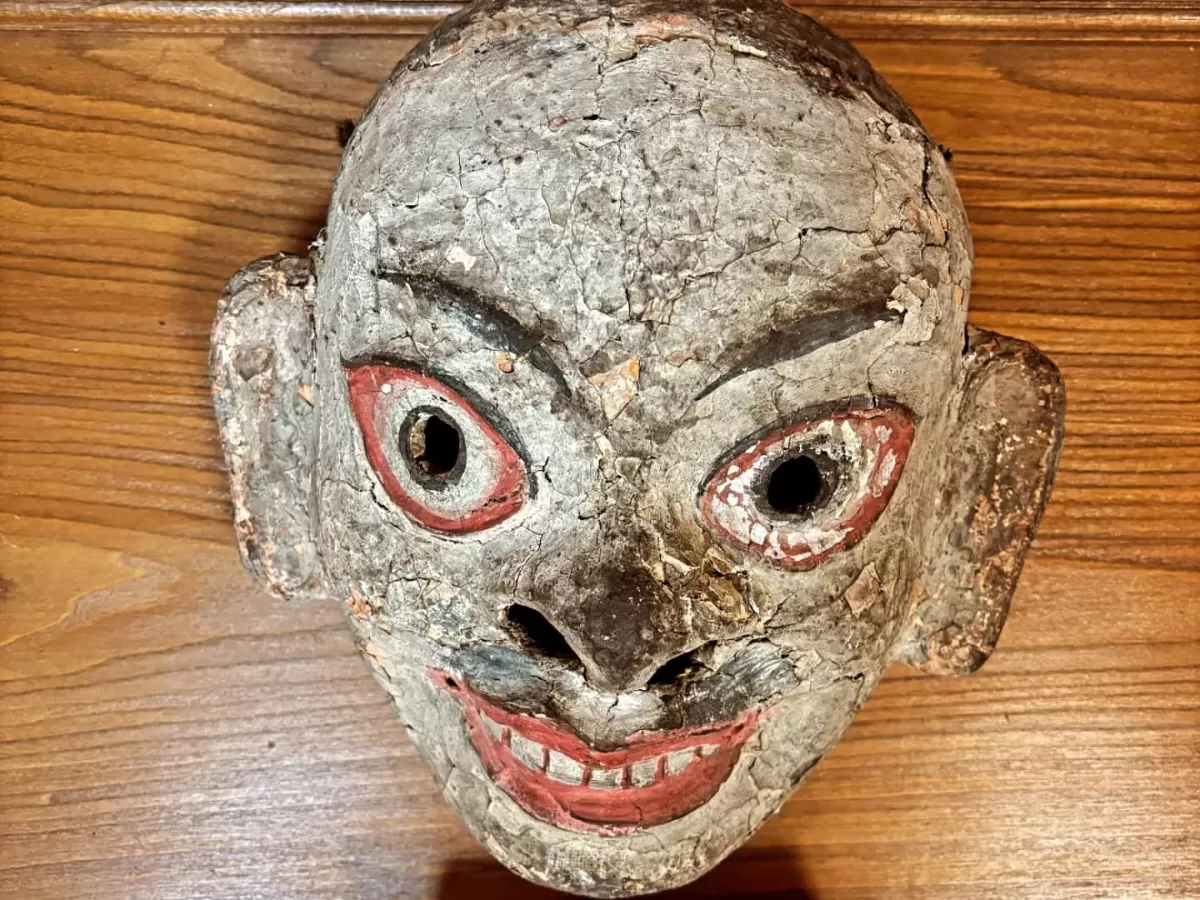 Hall of Fame Leh Ladakh Indian Army museum exhibit traditional Tibetan Ladakhi devil demon mask weathered gray red eyes teeth wooden carved artifact cultural display.