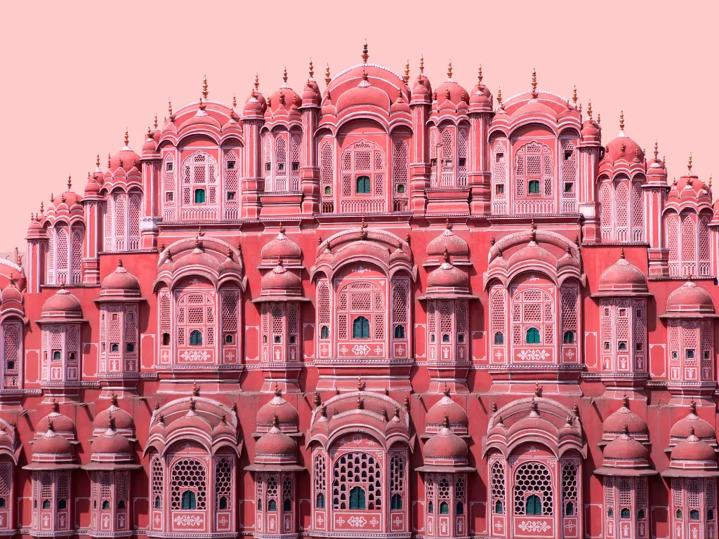 Hawa Mahal Jaipur pink hues day, featuring honeycomb windows jharokhas domes, perfect romantic experience Rajasthan tour packages.