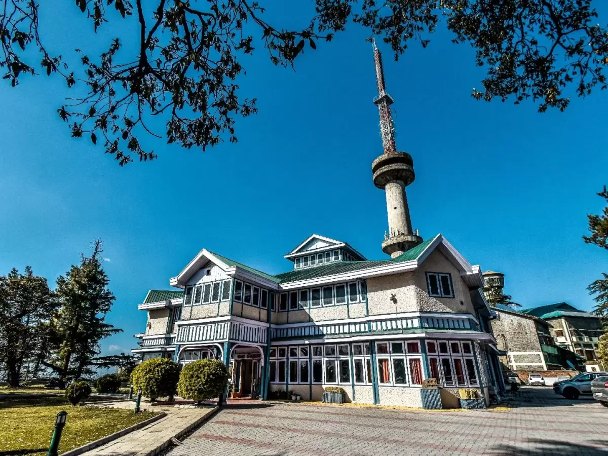 Himachal State Museum Shimla colonial Victorian building with tall TV transmission tower, green lawns trees blue sky, perfect heritage culture spot, Himachal Pradesh tour packages.