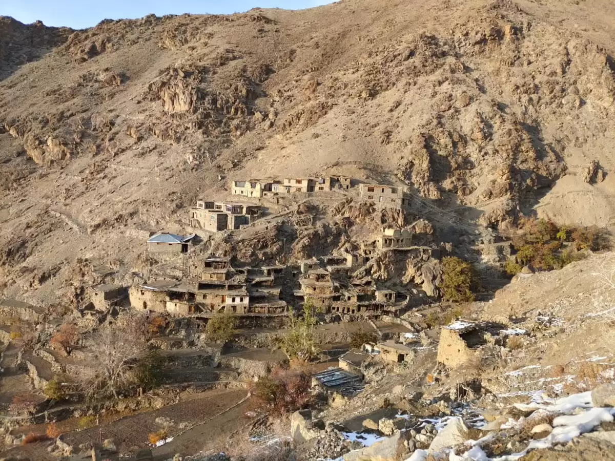 Hunderman Village Kargil Ladakh ghost village abandoned stone houses clustered on dramatic cliffside, barren Himalayan mountains with snow patches, sparse autumn trees, perfect border adventure India tour package.