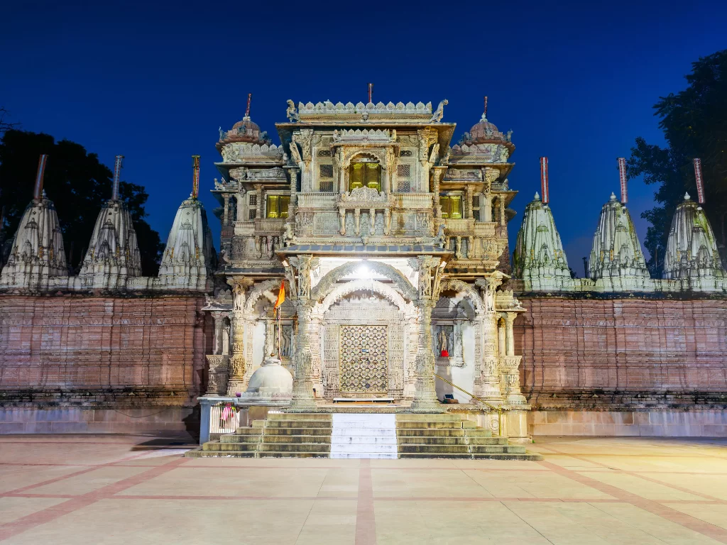 Hutheesing Jain Temple at Ahmedabad during evening, featuring ornate shikharas and illuminated facade, perfect cultural Gujarat tour package.