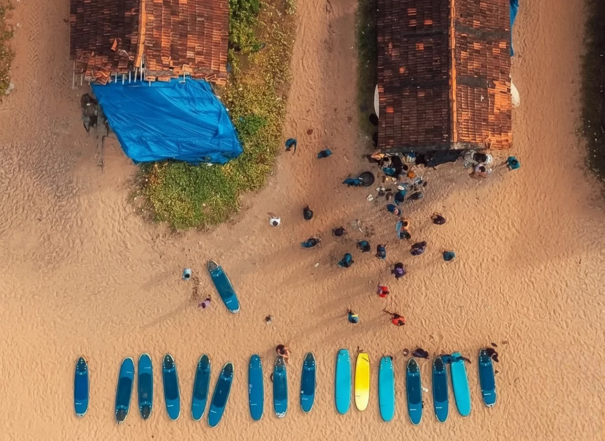 Varkala Beach Kerala aerial surfboard lineup golden sands surfers, blue yellow boards tiled huts palm beach crowd, perfect Kerala surf lessons cliff beach package. 