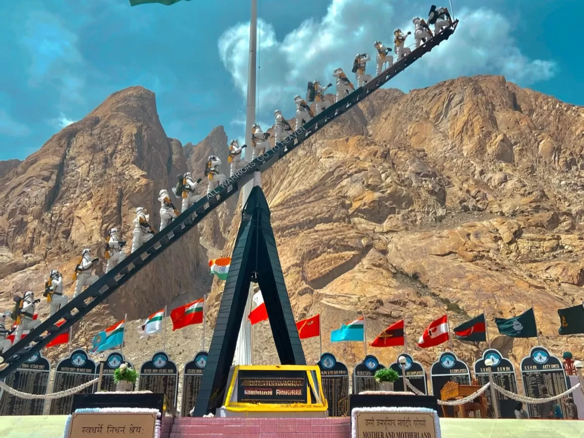 Siachen Warriors War Memorial monument Siachen Base Camp Ladakh Indian Army soldiers climbing ladder flagpole tricolor fluttering international flags rugged Karakoram mountains tribute martyrs tourist viewpoint.