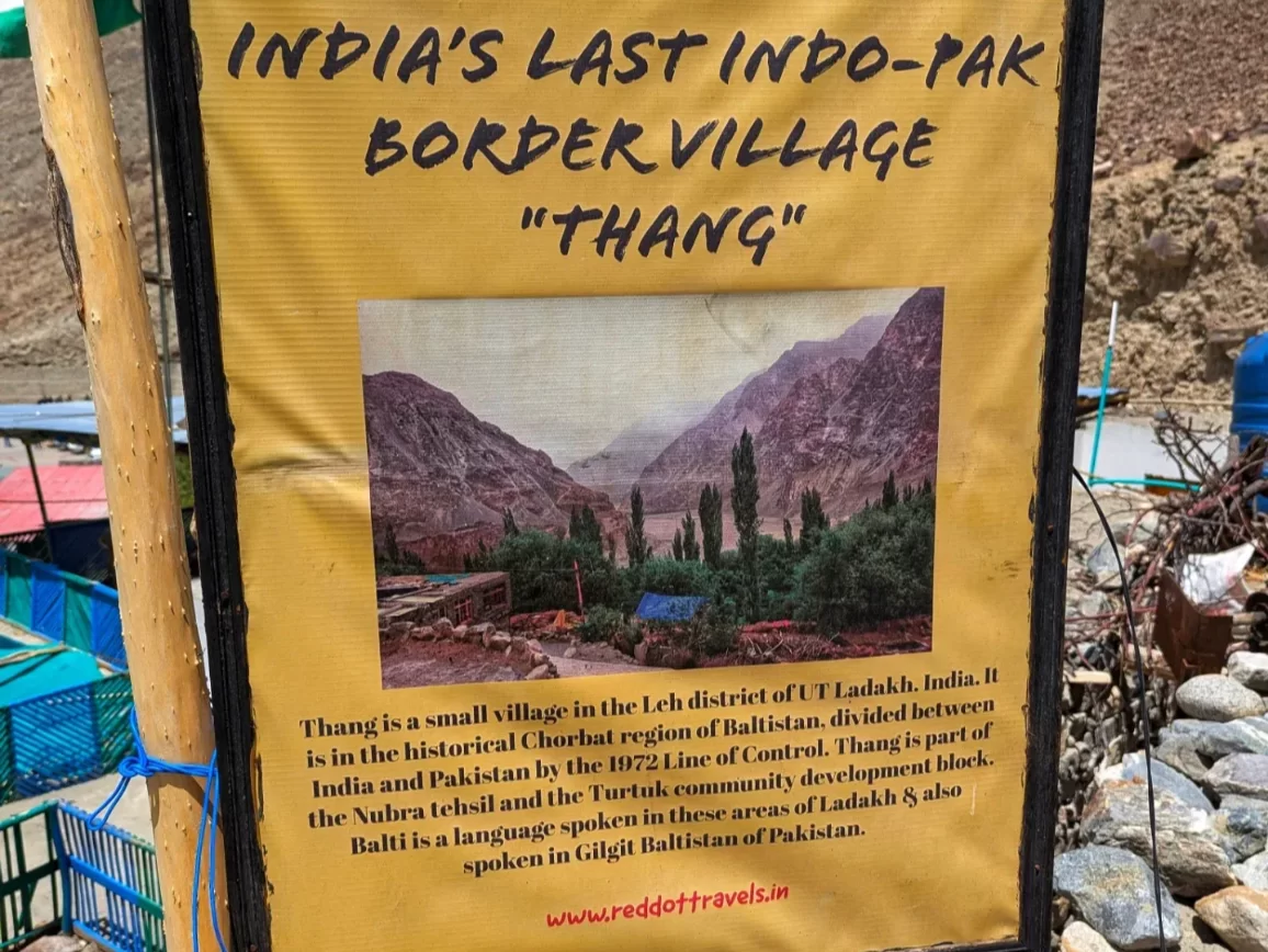 India's last Indo-Pak border village Thang signboard near Turtuk Nubra Valley Ladakh during clear day, featuring LOC history, mountains, perfect adventure Turtuk tour package.