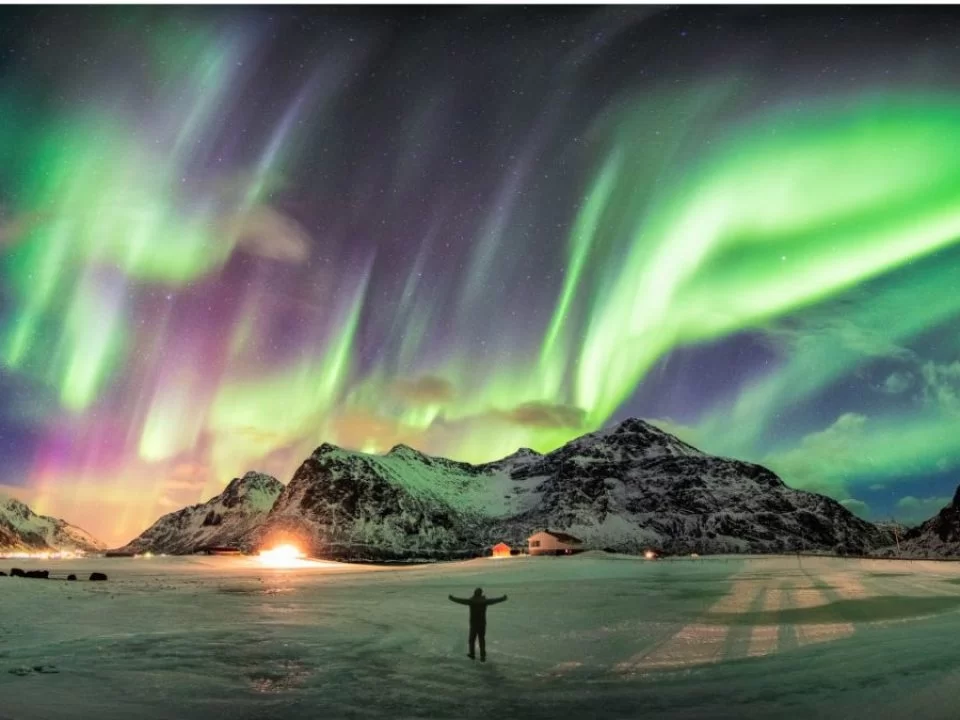 Hanle Ladakh airglow green purple aurora borealis snowy peaks silhouette adventurer icy lake frozen reflection cosmic night sky, IIA dark skies rare celestial event, perfect astrophotography stargazing package.