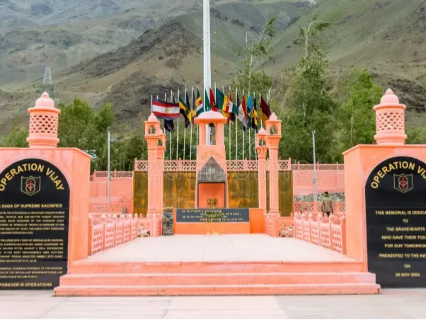 Drass War Memorial Ladakh Operation Vijay memorial pink pavilions international flags flagpole snowy mountains Kargil War tribute supreme sacrifice heroes, perfect Ladakh heritage tour package.