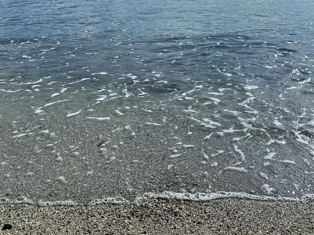 Waves crashing at Corbyn's Cove Beach during clear daytime, featuring turquoise ocean, sandy shore, foam crests, perfect adventure experience with Andaman tour package.