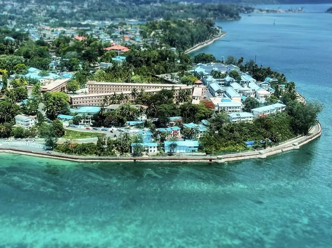 Aerial view of Cellular Jail Port Blair Andaman Nicobar Islands during clear skies, featuring radial wings, surrounding buildings, coastal shoreline, perfect heritage experience Andaman tour package.