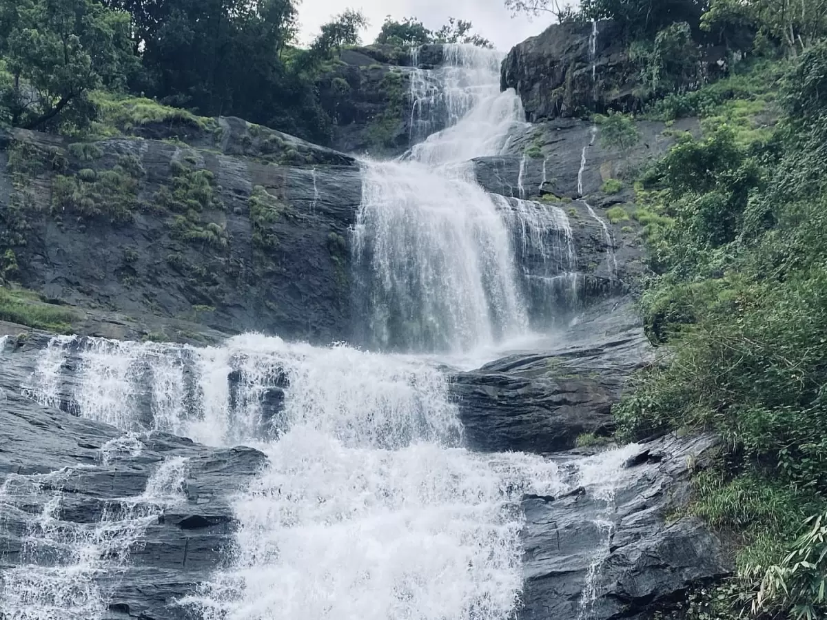 Majestic Valara Waterfalls Kerala misty cascade, featuring multi-tiered falls lush green rocks rainforest surroundings, perfect Kerala waterfall tour package