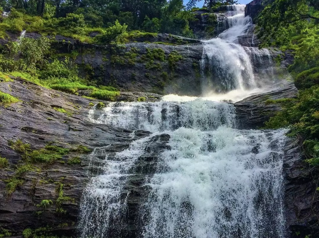 Majestic multi-tiered Cheyyappara Waterfall cascading down rocky cliffs in Idukki Kerala during monsoon season, featuring lush green Western Ghats forest mist spray, perfect nature adventure experience with Cheyyappara Waterfall Kerala tour package. 