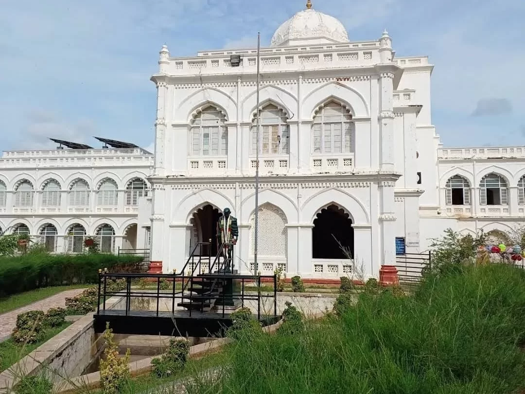 Gandhi Memorial Museum Madurai Tamil Nadu majestic white Indo-Saracenic architecture building with dome arches surrounded by trees under blue sky with clouds, historic freedom struggle tour package