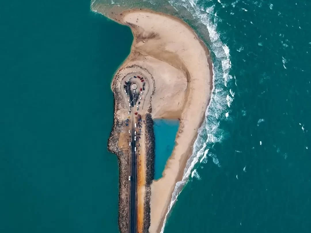 Aerial Arichal Munai Beach Dhanushkodi sunny day, Pamban road watchtower sandbar waves turquoise seas rock jetties; perfect Rameswaram Dhanushkodi tour package.