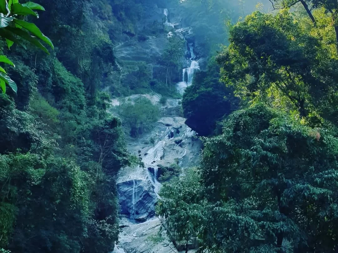 Lush green forested hills multi-tiered cascading Siruvani Waterfalls Tamil Nadu Western Ghats sunlight filtering golden hour, perfect eco-tourism waterfall Coimbatore day trip package.