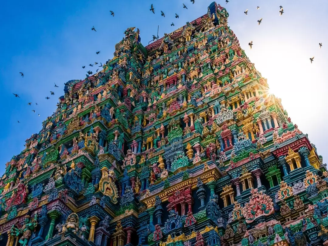 Kapaleeshwarar Temple gopuram in Mylapore Chennai during clear sunny day, featuring vibrant multicolored sculptures, intricate carvings, flocking birds, perfect cultural heritage experience Chennai temple tour package.