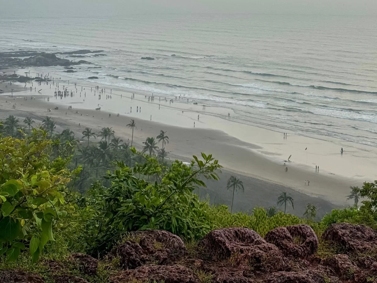 Aerial view of serene Candolim Beach Goa during misty morning, featuring sandy shore Arabian Sea waves distant palm trees crowds, perfect beach relaxation experience with Candolim Beach Goa tour package.