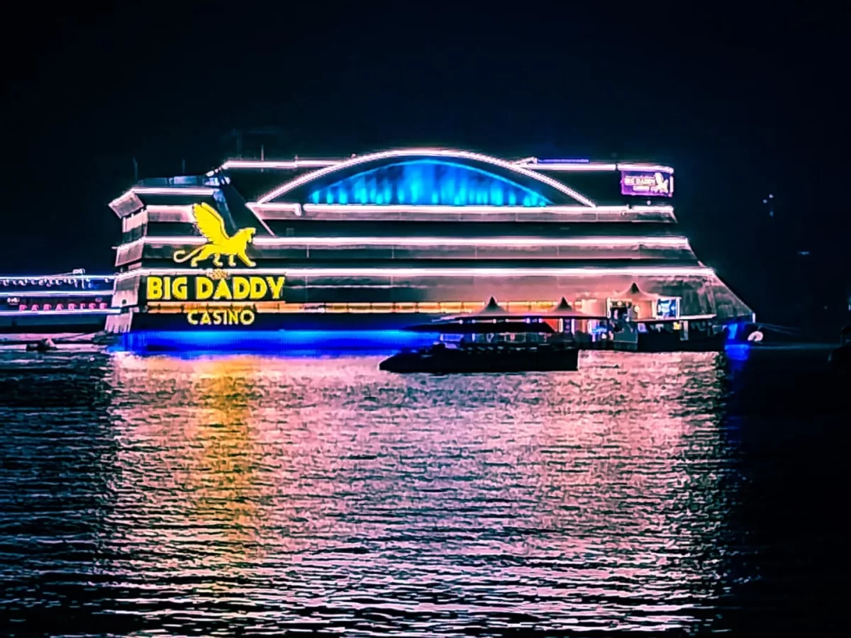 Lit Big Daddy Casino ship on Mandovi River Goa during night, featuring neon blue dome golden lion logo reflections, perfect gaming adventure experience with Big Daddy Casino Goa tour package.