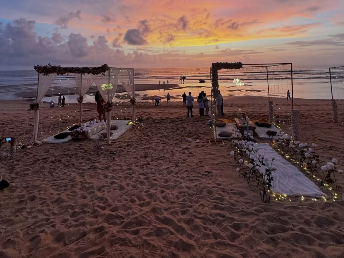 Beach wedding setup at Calangute Beach Goa during sunset, featuring flower mandaps cushions guests Arabian Sea, perfect romantic experience with Calangute Beach Goa tour package.