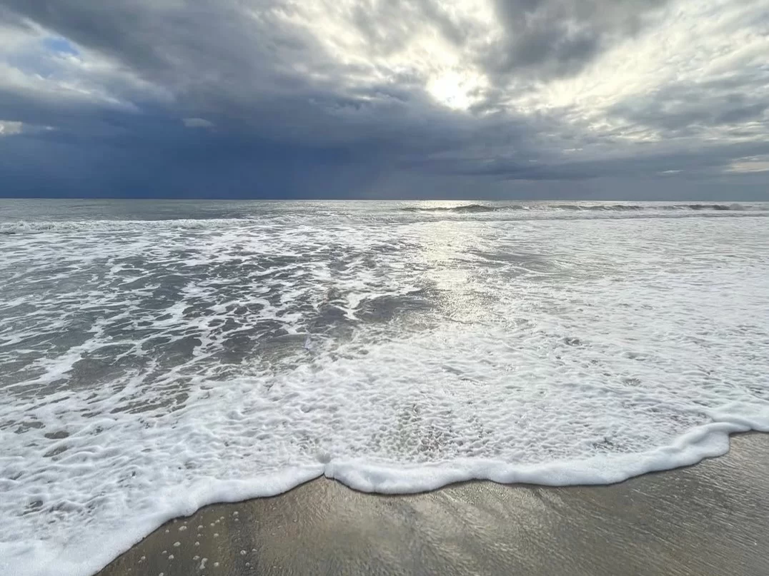 Cherai Beach sunset in Kochi Kerala during dramatic cloudy sky, featuring foaming waves, golden sand, serene Arabian Sea, perfect romantic Cherai Beach tour package. 