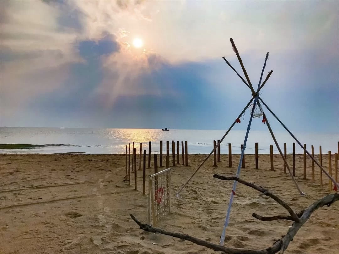 Bamboo tent structure sunset Betalbatim Beach Goa golden glow, featuring wooden poles lanterns distant sea waves sandy shore, perfect South Goa beach tour package.