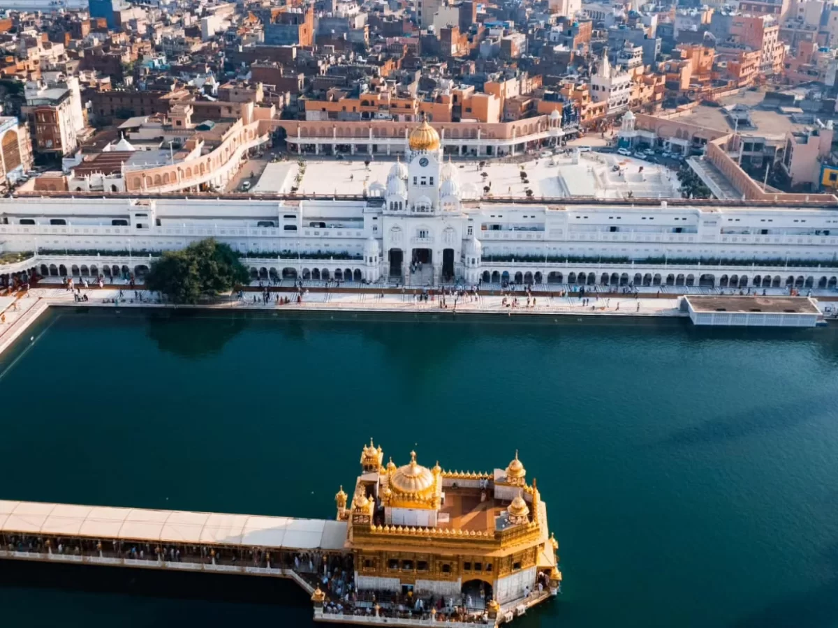 Aerial Golden Temple Amritsar sarovar Harmandir Sahib complex, golden domes white marble parikrama Amritsar cityscape, perfect Punjab Sikh holy shrine package.