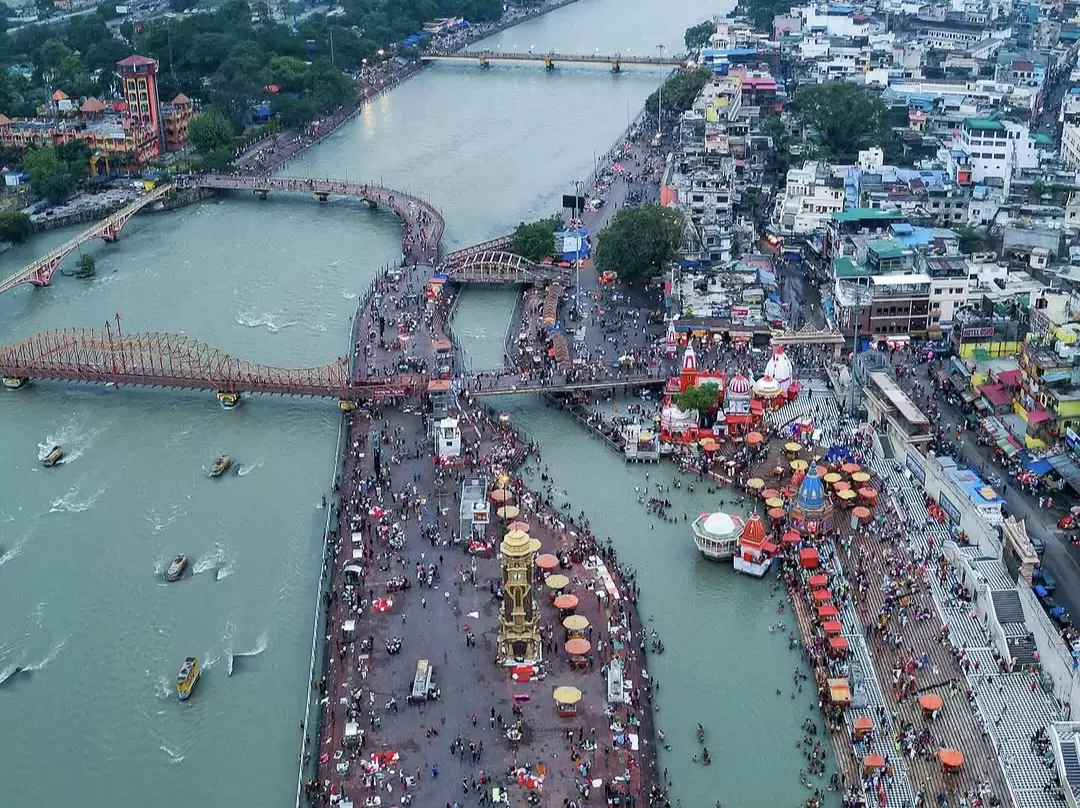Har Ki Pauri Haridwar aerial view of Ganga ghats colorful tents temples boats bridge crowds Hari ki Pairi tower during festival, perfect pilgrimage aarti spot, Uttarakhand tour packages.