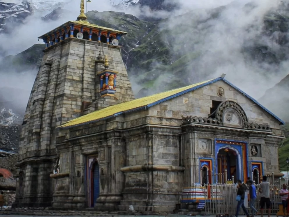 Kedarnath Temple at Kedarnath Uttarakhand during misty weather, featuring Himalayan mountains and golden spire, perfect spiritual experience Uttarakhand tour package.