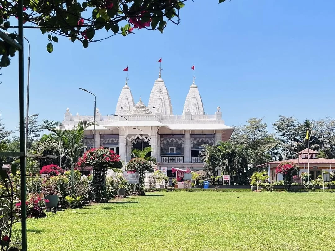 Shree Narayani Dham Temple Lonavala white marble shikharas green lawns palms, red flags bougainvillea blue skies Rajasthan style, perfect Maharashtra spiritual temple complex package.