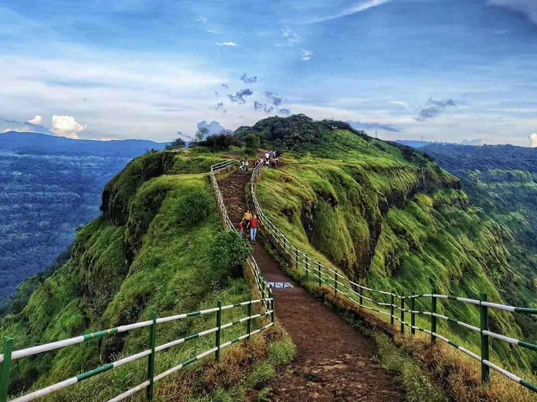 Tourists hiking staircase trail at Lodwick Point Srinagar during sunny day, featuring green hilltop and valley views, perfect adventure experience in Srinagar tour package.