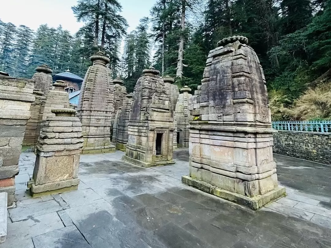 Jageshwar Temple at Almora during foggy morning, featuring weathered shikharas, cedar forests, stone shrines, perfect spiritual experience Uttarakhand tour packages. 