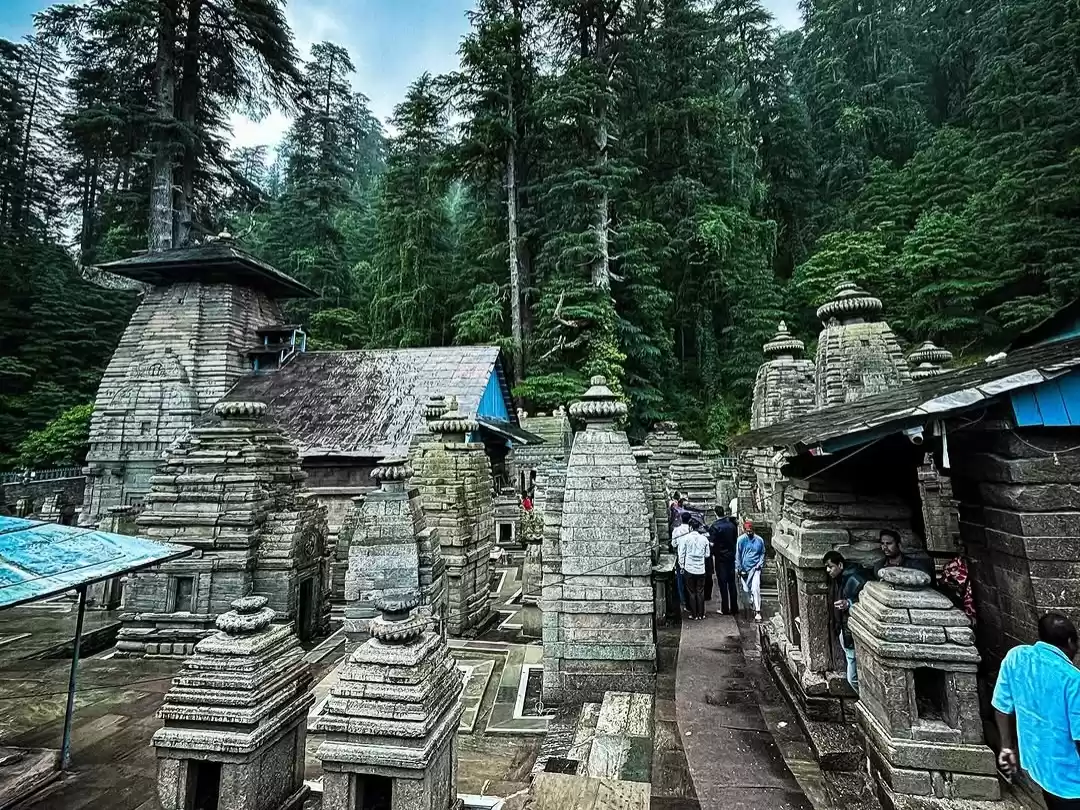 Jageshwar Temple at Almora during misty weather, featuring stone shikharas, deodar forests, devotees, perfect spiritual experience Uttarakhand tour packages.