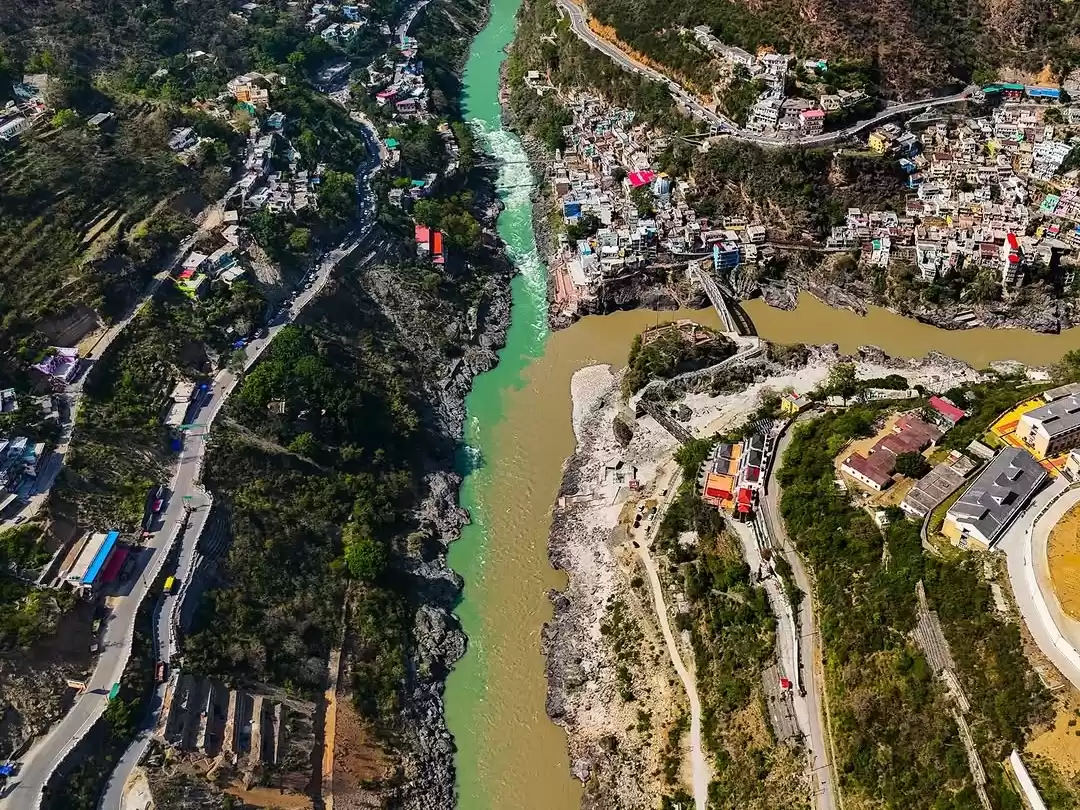 Devprayag Uttarakhand aerial drone view colorful buildings roads green turquoise Bhagirathi brown Alaknanda rivers merging forested hills mountains, perfect Uttarakhand tour packages.