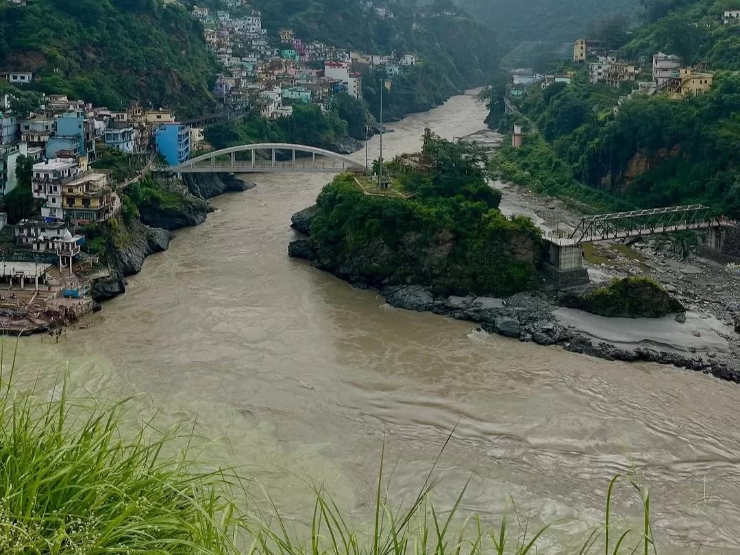 Devprayag Uttarakhand colorful houses riverside two bridges brown Alaknanda River green hills ghats mountains misty weather, perfect Uttarakhand tour packages.