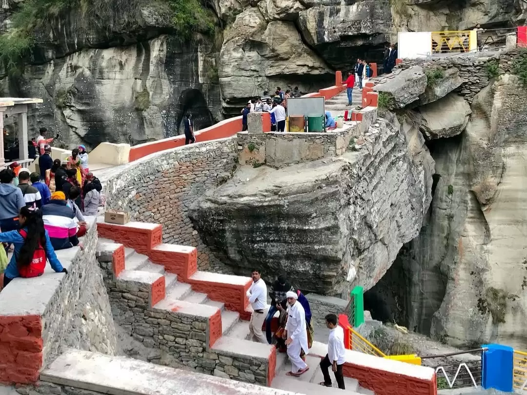 Bheem Pul Mana Village Badrinath tourists red bridge steps rocky gorge green hills scaffolding Uttarakhand tour packages.