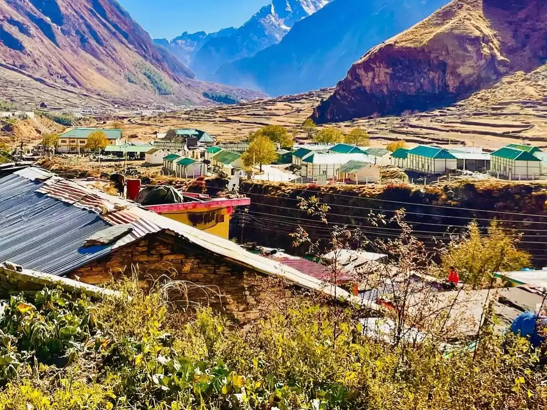 Mana Village Uttarakhand green roof cottages terraced fields snowy Himalayan peaks autumn colors Badrinath India's last village Uttarakhand tour packages. 