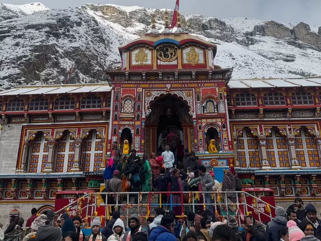 Badrinath Temple Uttarakhand ornate red gold facade snowy Himalayan peaks pilgrims winter coats Char Dham Yatra Uttarakhand tour packages.