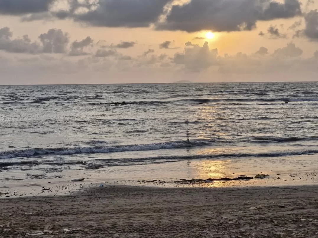 Kihim Beach Alibaug during dramatic sunset, featuring Arabian Sea waves, rocky shoreline, golden horizon glow, perfect romantic experience Mumbai Konkan tour package.