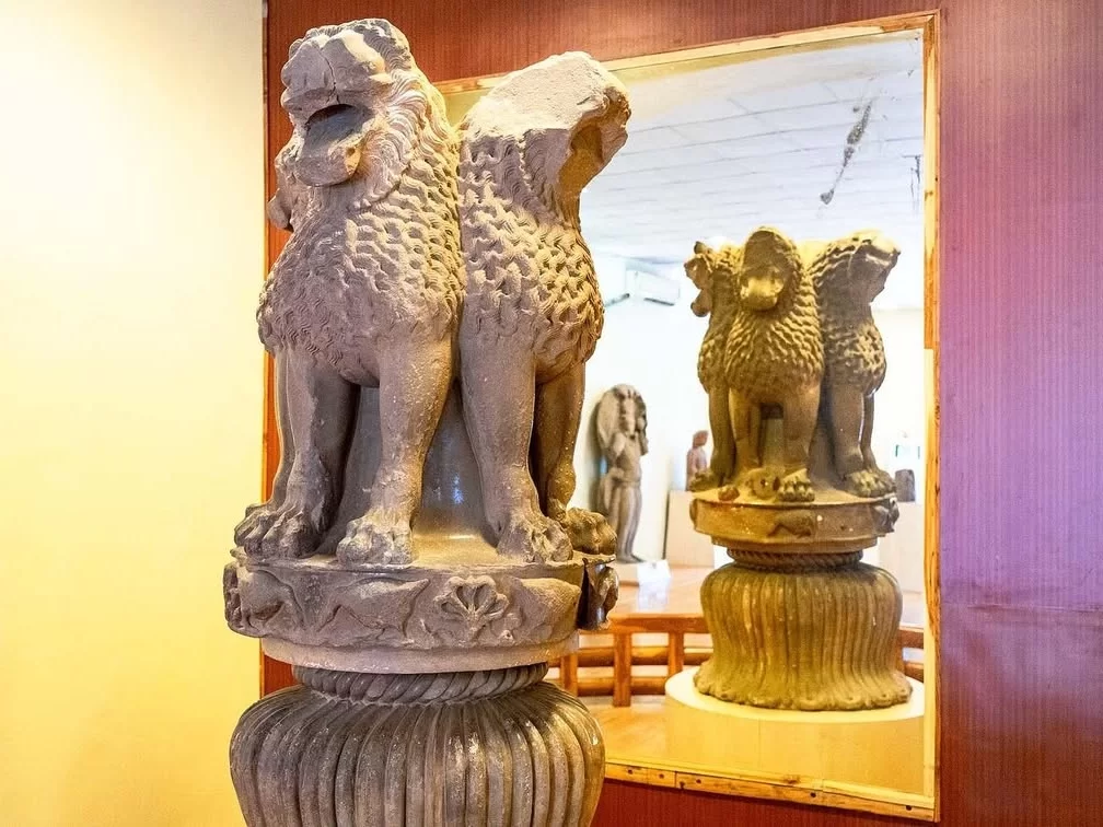 Lion Capital display at Sanchi Archaeological Museum during clear day, featuring four lions back-to-back on abacus with mirror reflection, perfect heritage experience in Madhya Pradesh tour package.