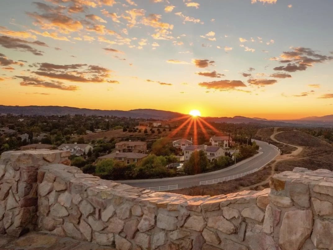 Panorama Point Matheran golden hour aerial view of village homes curving roads hills sunset clouds stone wall foreground, perfect panoramic sunset vista, Maharashtra hill station tour packages.