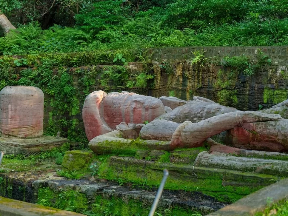 Shesh Shaiya at Bandhavgarh National Park under dappled jungle light, featuring moss-covered reclining Vishnu with Sheshnag head amid lush forest, perfect heritage experience with Madhya Pradesh tour packages.