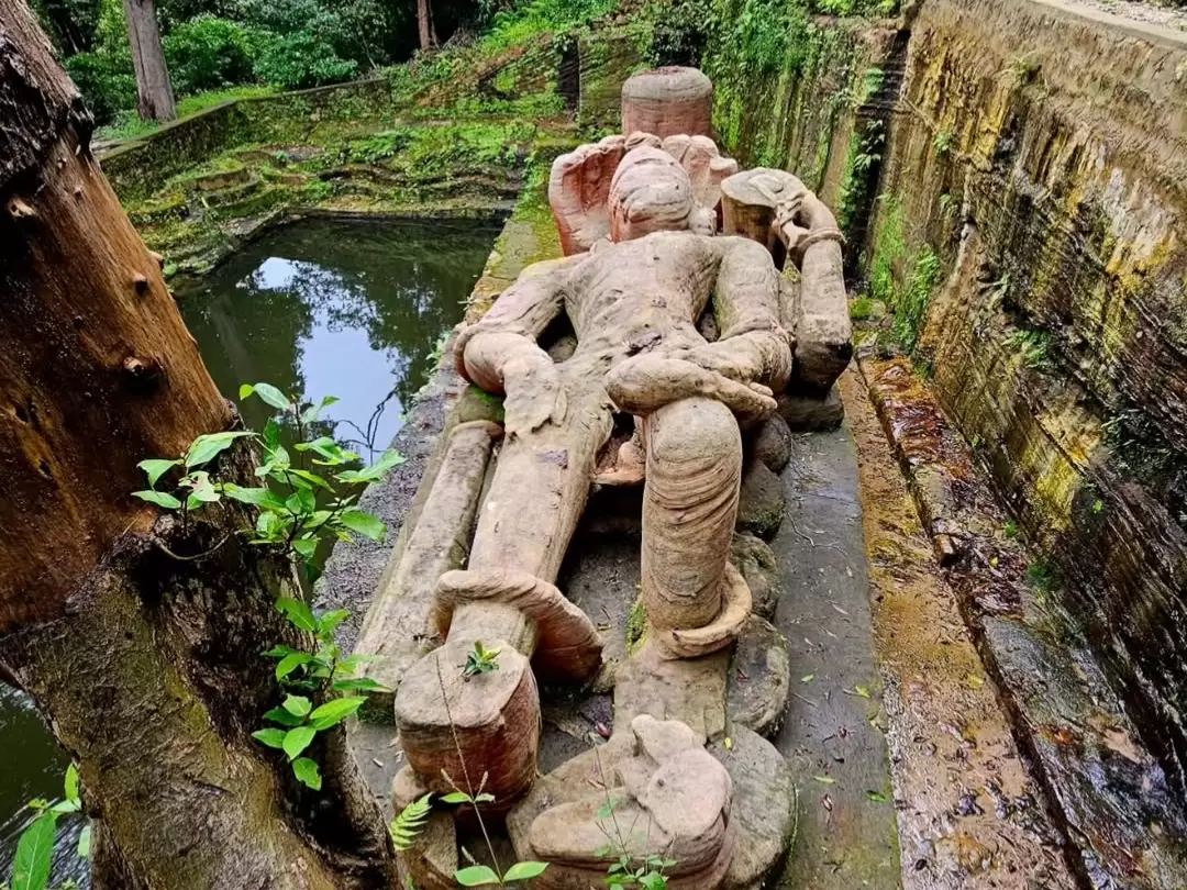 Shesh Shaiya reclining Vishnu statue at Bandhavgarh National Park amid lush jungle, moss-covered with sacred pool reflections, perfect wildlife heritage experience with Madhya Pradesh tour packages.