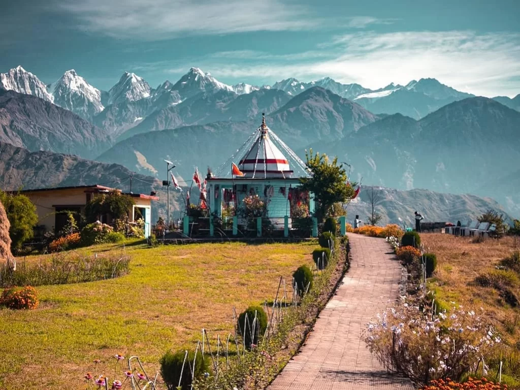 Nanda Devi Temple at Munsiyari during sunny weather, featuring Panchachuli peaks, flags, gardens, perfect cultural adventure, Uttarakhand tour packages.