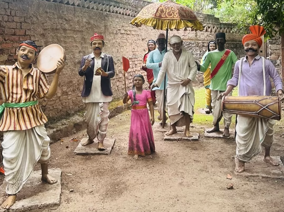 Sai Baba procession statues at Sai Heritage Village near Naini Lake Nainital, featuring drummers, musicians, devotees, little girl and Sai Baba under umbrella, perfect cultural heritage experience Uttarakhand tour package.